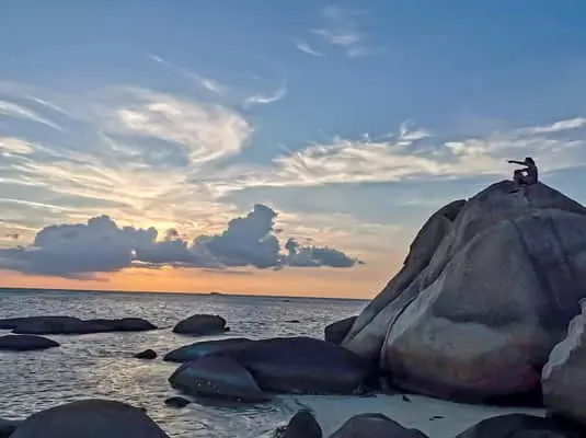 plage avec une personne sur un rocher plage avec une personne sur un rocher